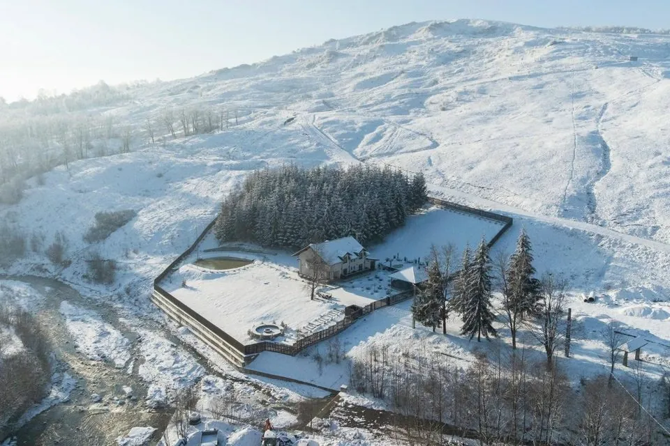 Vedere aeriană a întregii proprietăți iarna, înconjurată de munți înzăpeziți