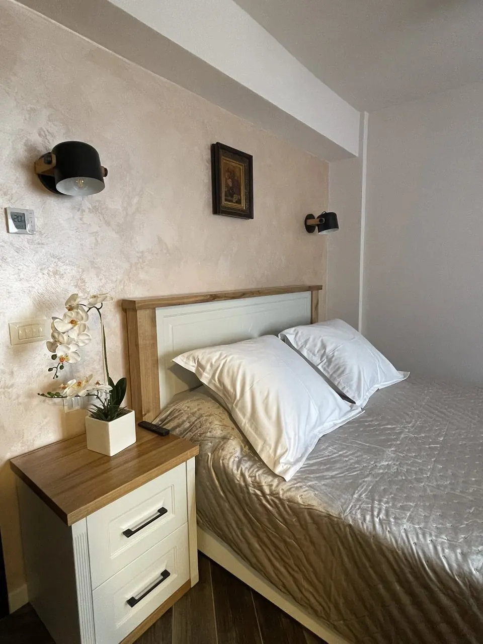 Dormitor cu mobilier crem și tablou clasic