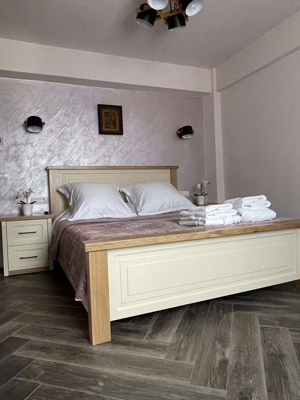 Dormitor cu pat matrimonial și prosoape pregătite