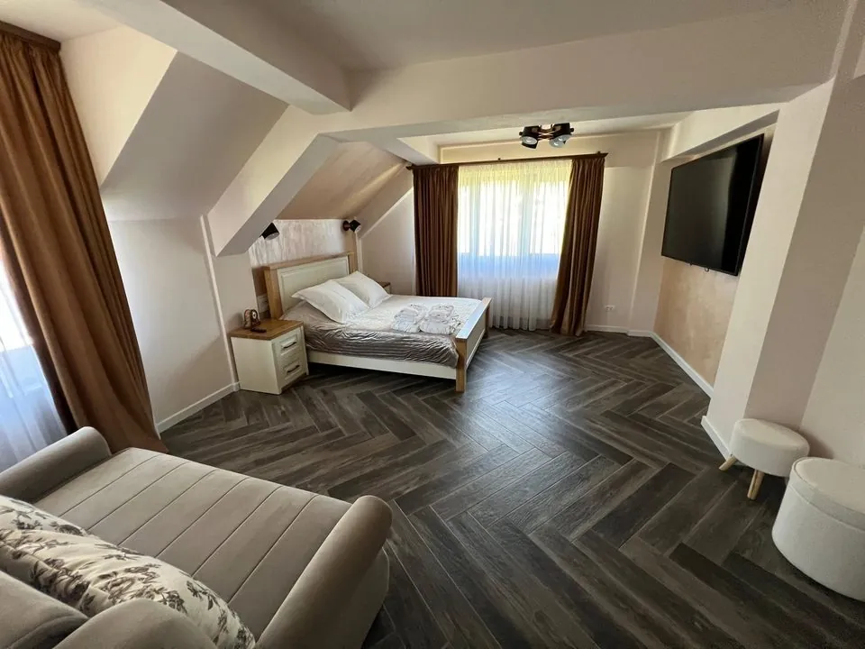 Dormitor spațios cu pat matrimonial și canapea extensibilă